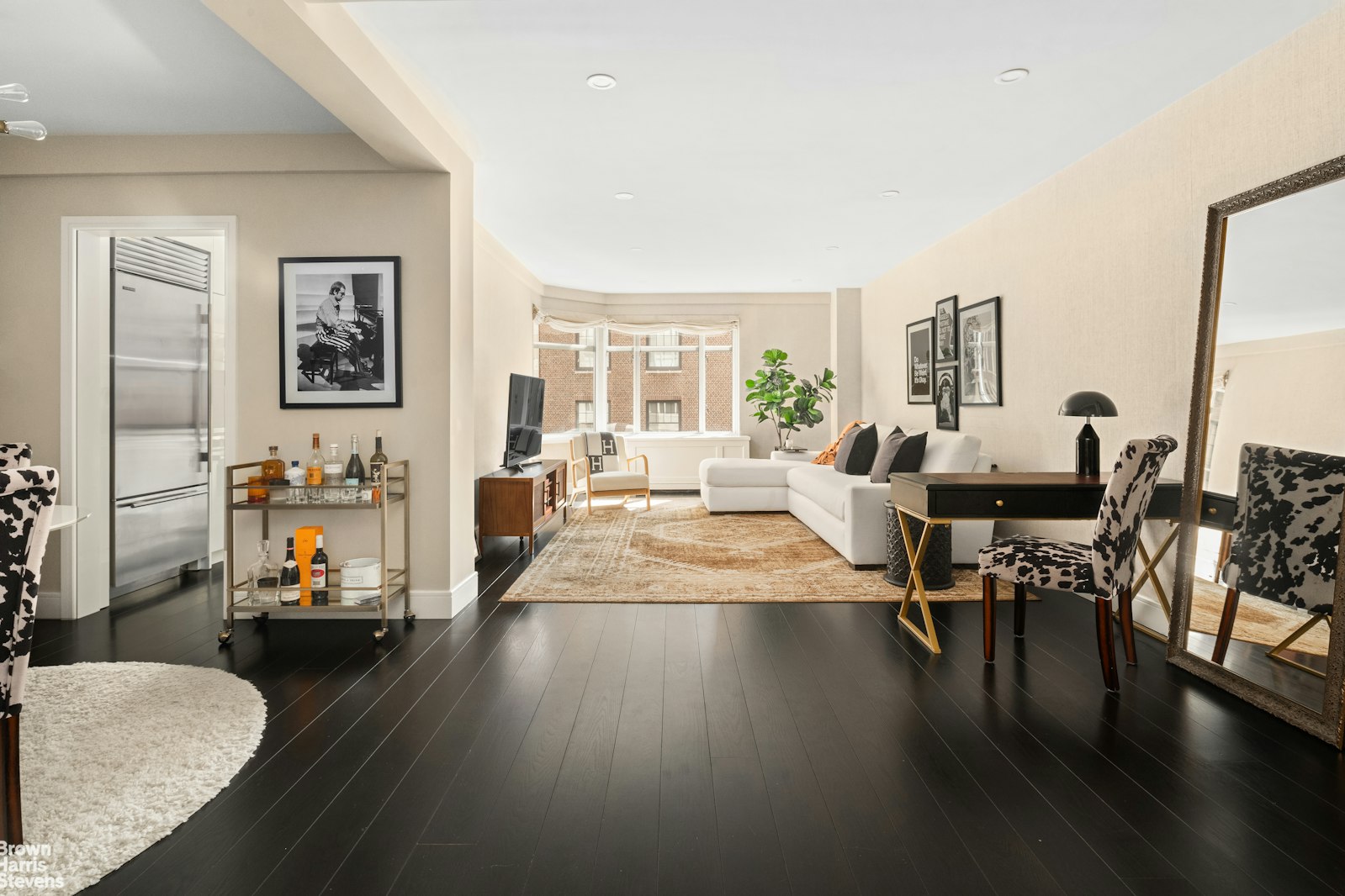 a living room with furniture floor to ceiling window and wooden floor