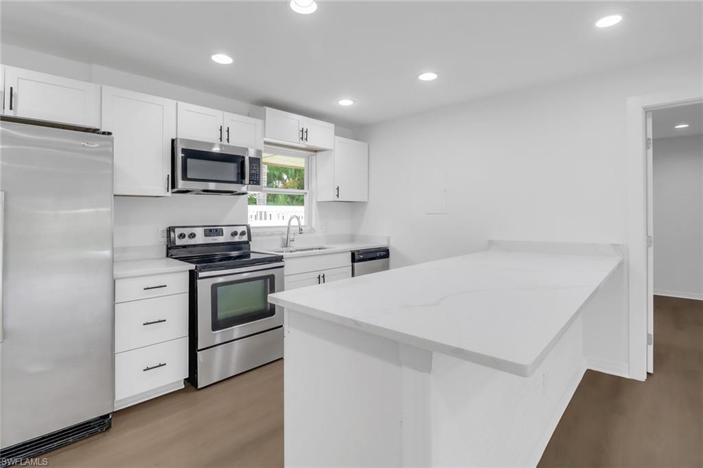 a kitchen with white cabinets and stainless steel appliances