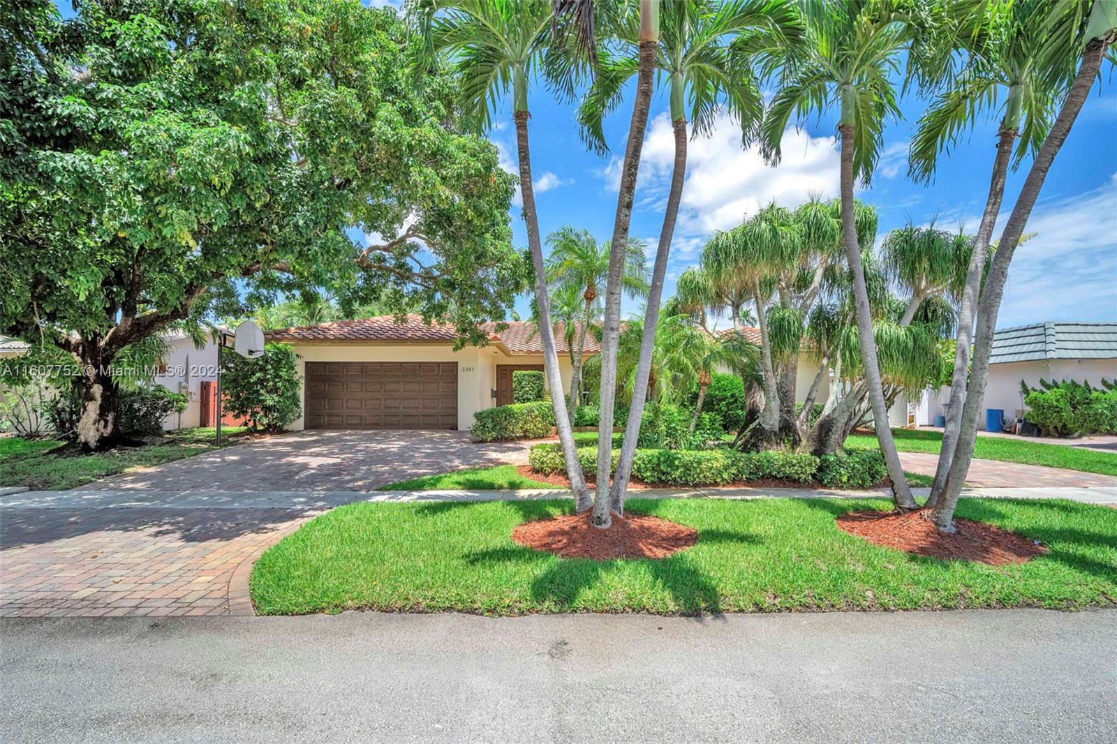 a front view of a house with a yard and palm trees