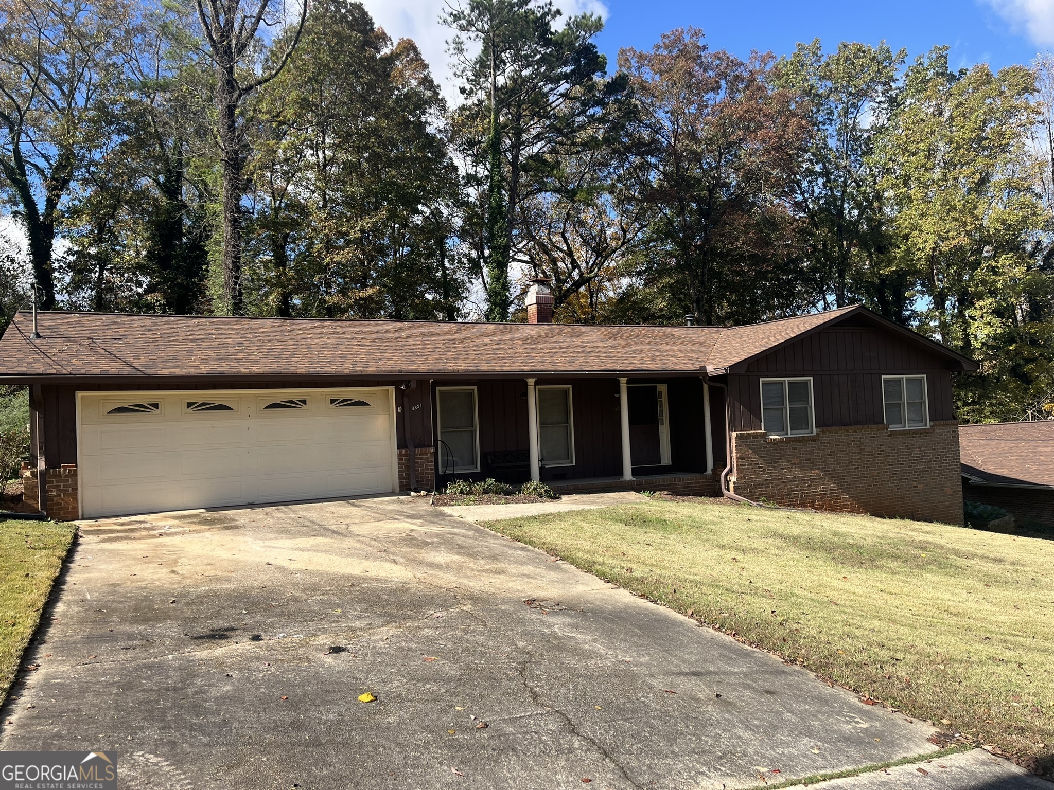 a front view of a house with a yard and trees