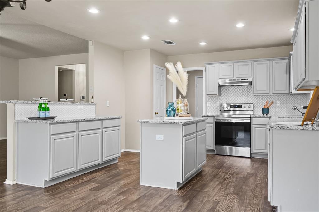 a kitchen with granite countertop white cabinets and white appliances