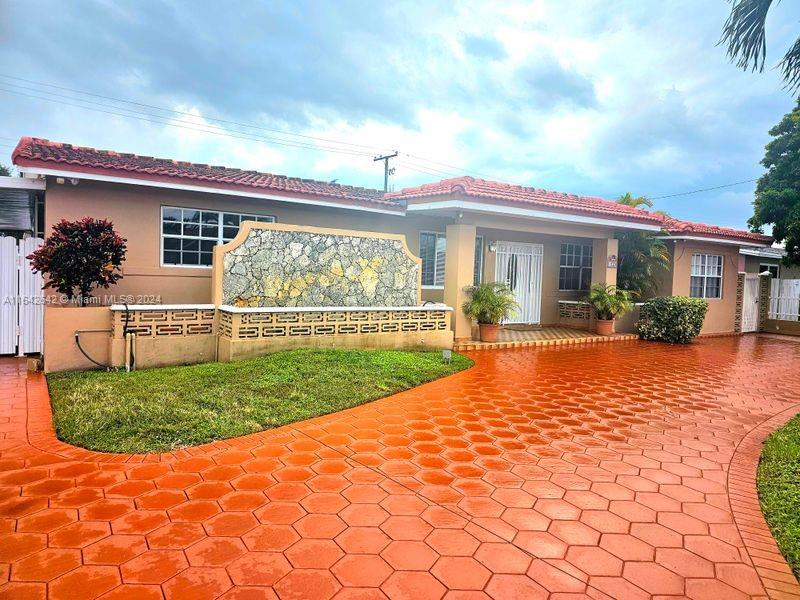 a view of a house with backyard and sitting area