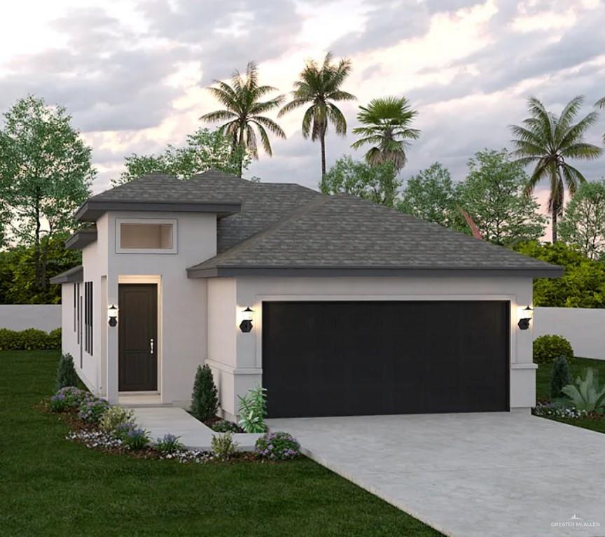 View of front of house with a garage and a lawn