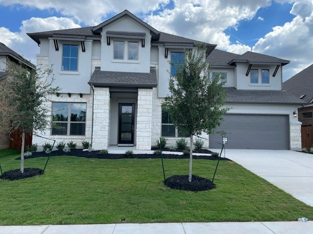 a front view of a house with a yard and trees