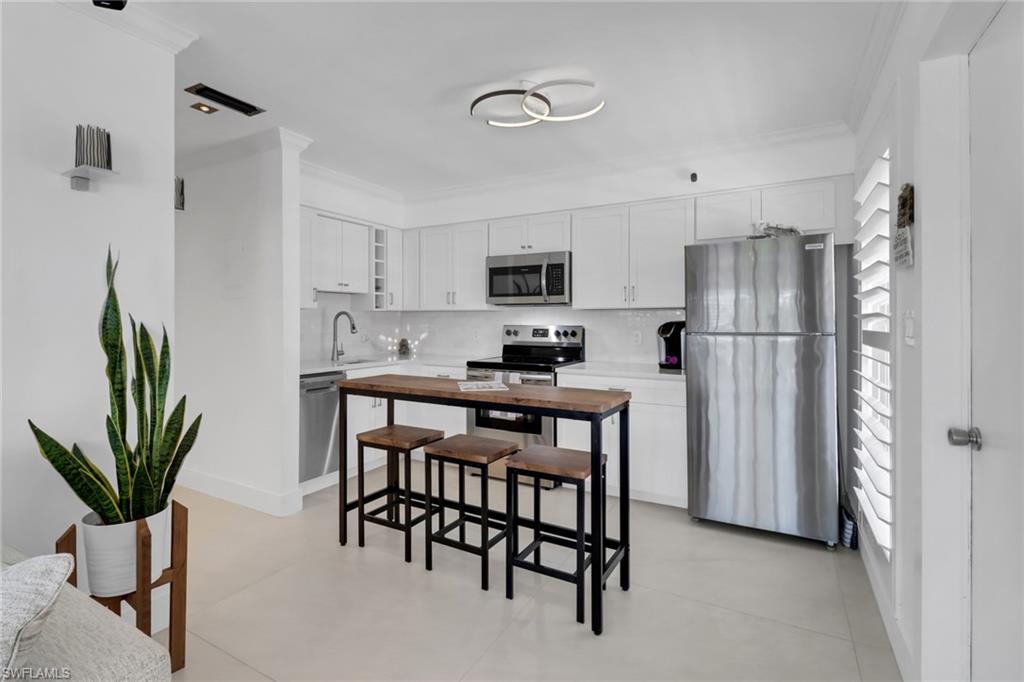 a kitchen with stainless steel appliances granite countertop a refrigerator and a stove top oven