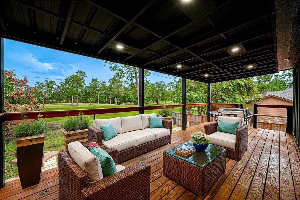 a view of a patio with couches chairs dining table and chairs with wooden floor