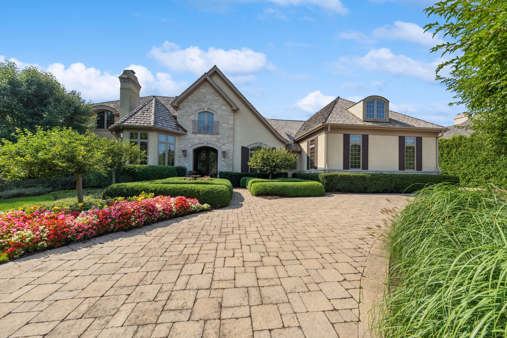 a front view of a house with a yard and potted plants