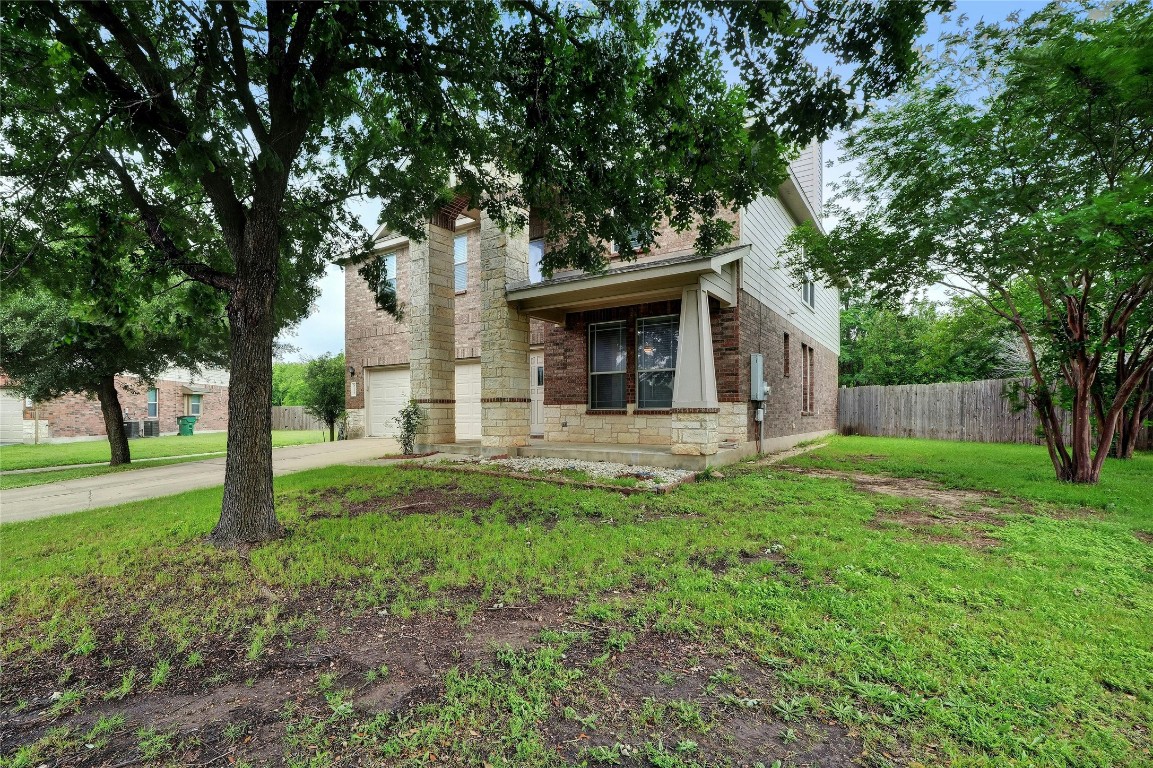 a view of a house with backyard and a tree