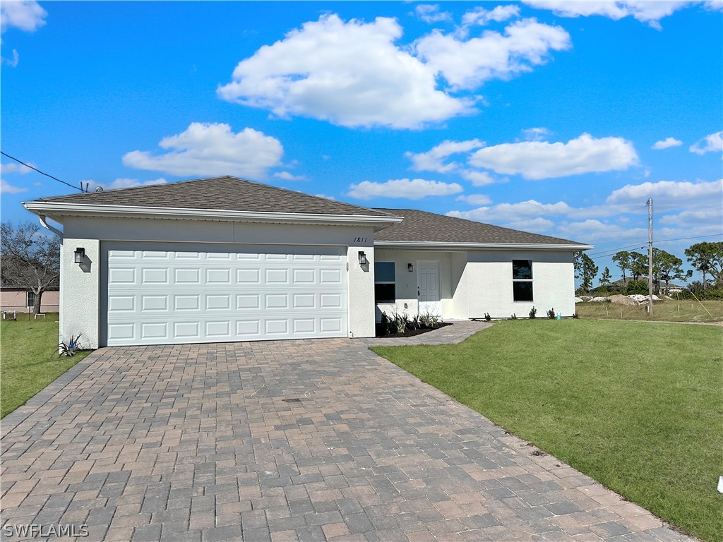 a front view of a house with a yard and garage