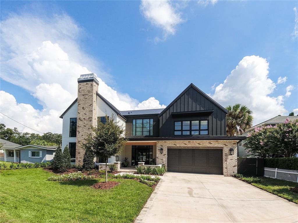 a front view of a house with a yard garage and outdoor seating