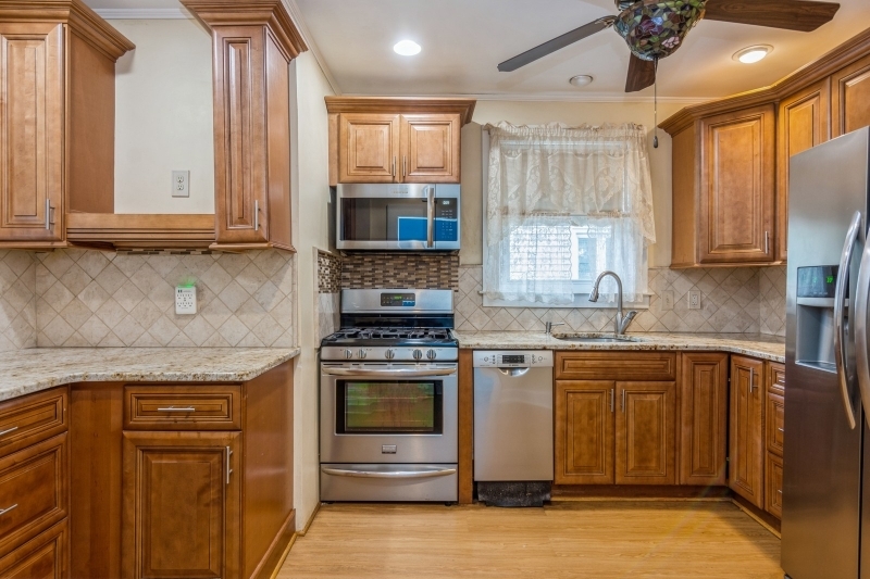 a kitchen with stainless steel appliances granite countertop a stove a sink and a microwave