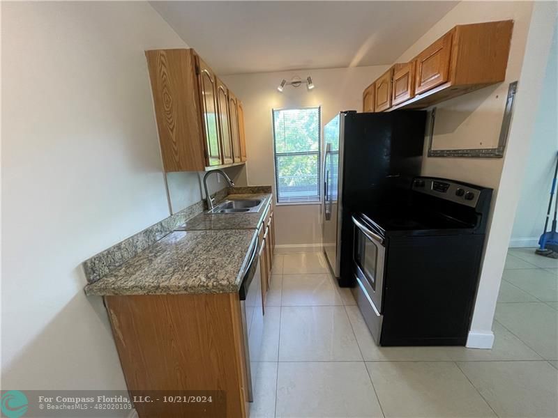 a kitchen with stainless steel appliances granite countertop a refrigerator and a stove