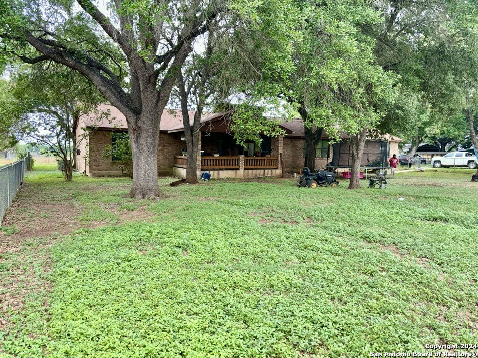 a view of a house with a yard and tree s