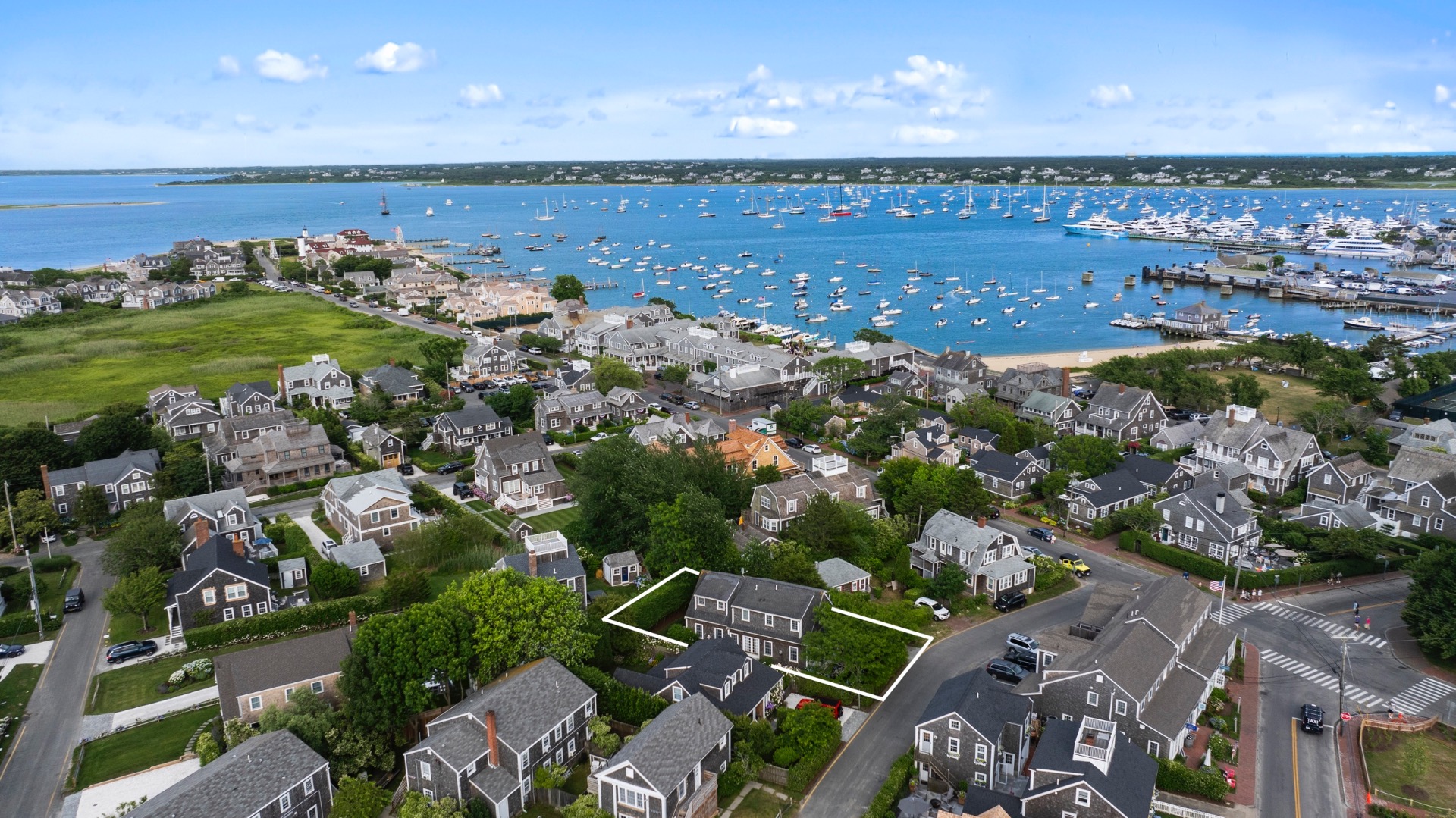 an aerial view of a city with lots of residential buildings ocean and mountain view in back