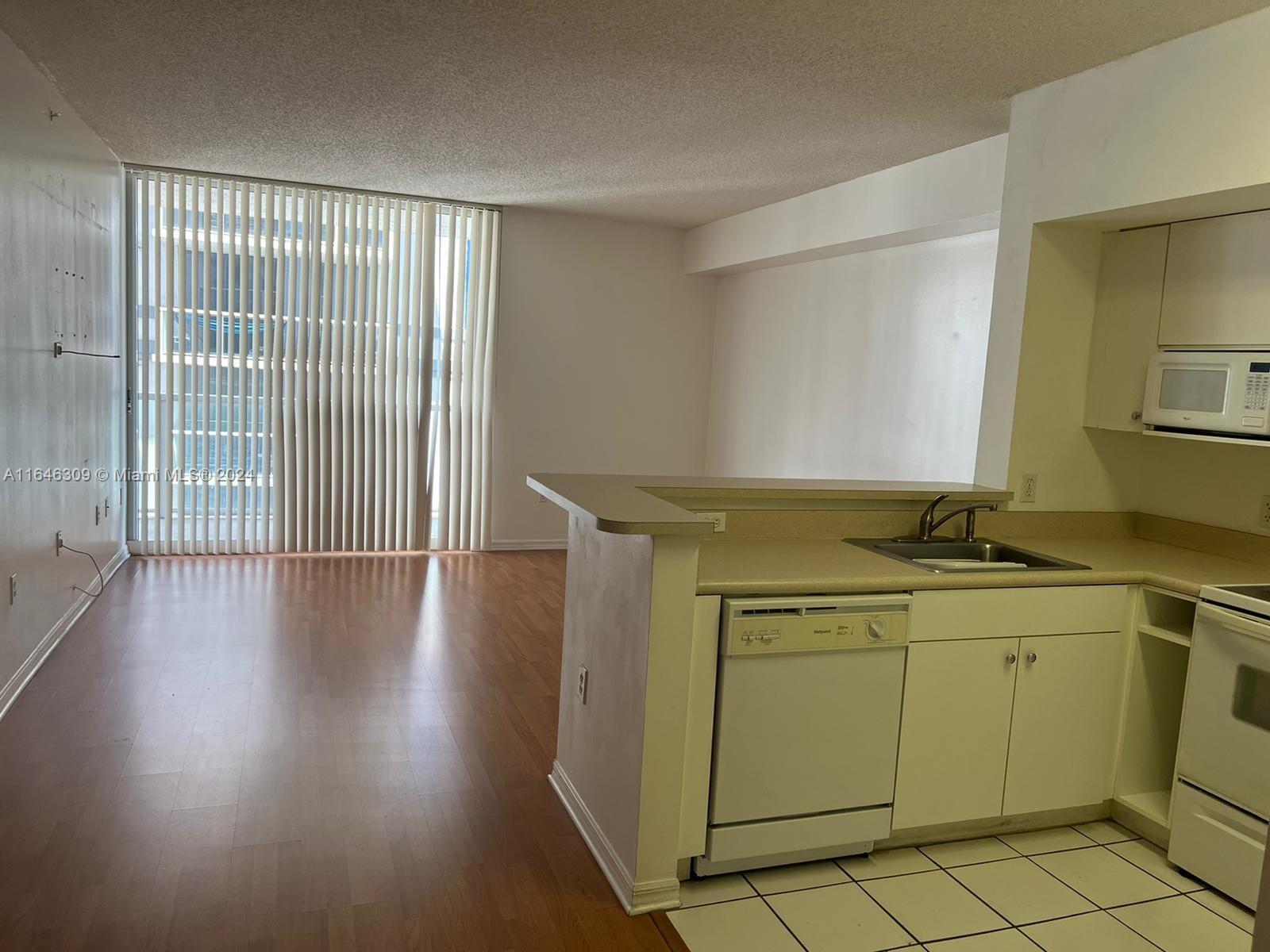 a view of a kitchen with wooden floor and a sink