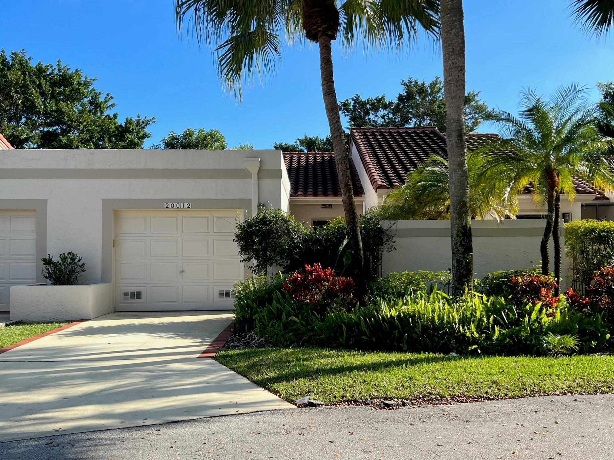 a view of a house with a yard and a palm tree