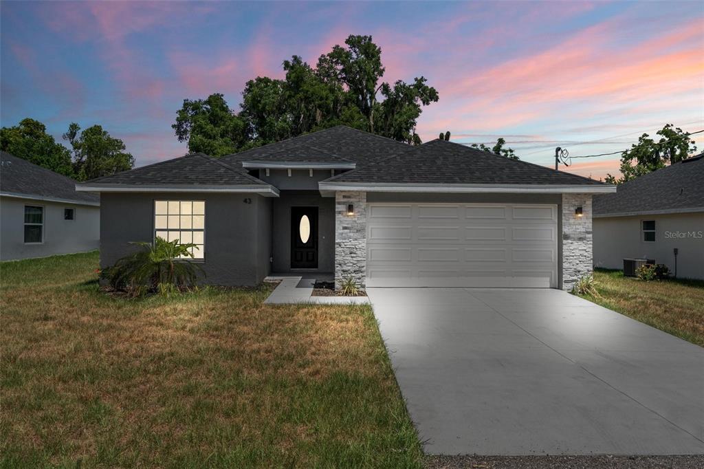 a front view of a house with a yard and garage