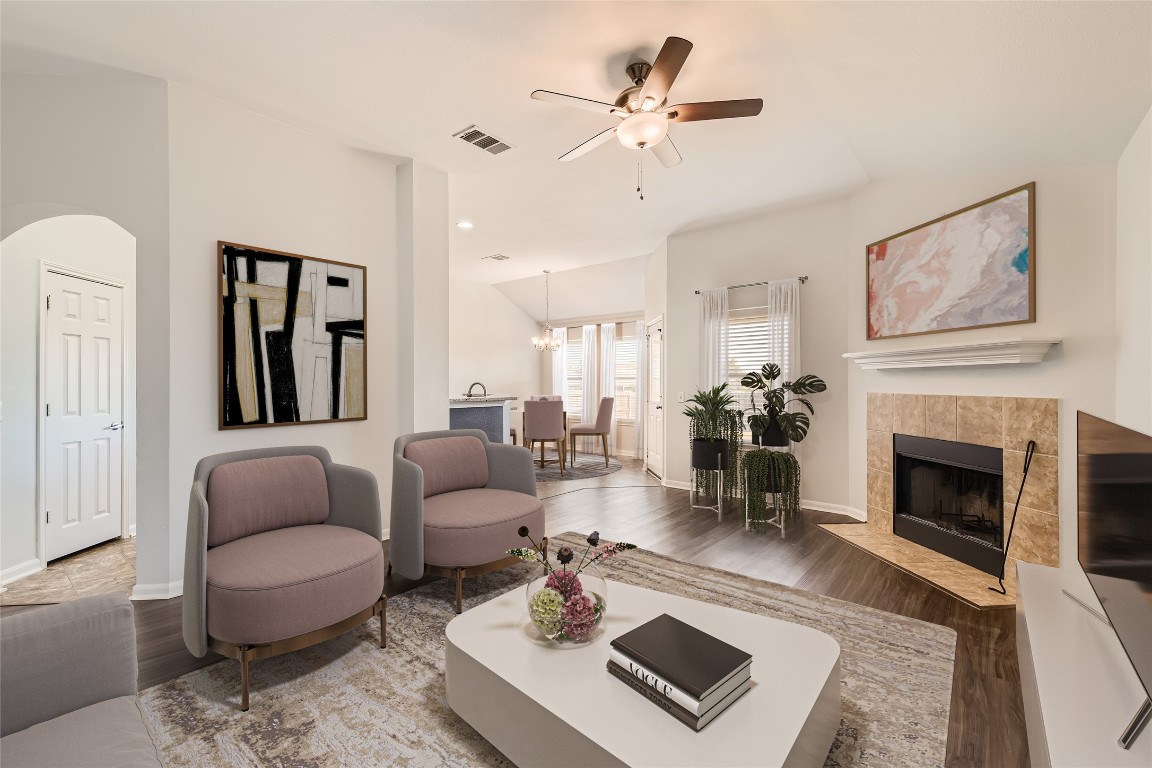 a living room with furniture a fireplace and a chandelier