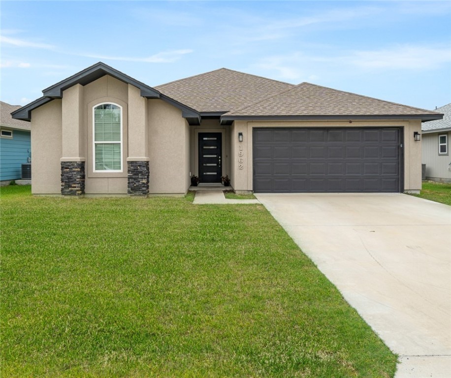 a front view of a house with a yard and garage