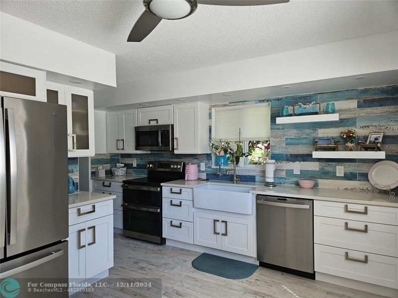 a kitchen with white cabinets and stainless steel appliances