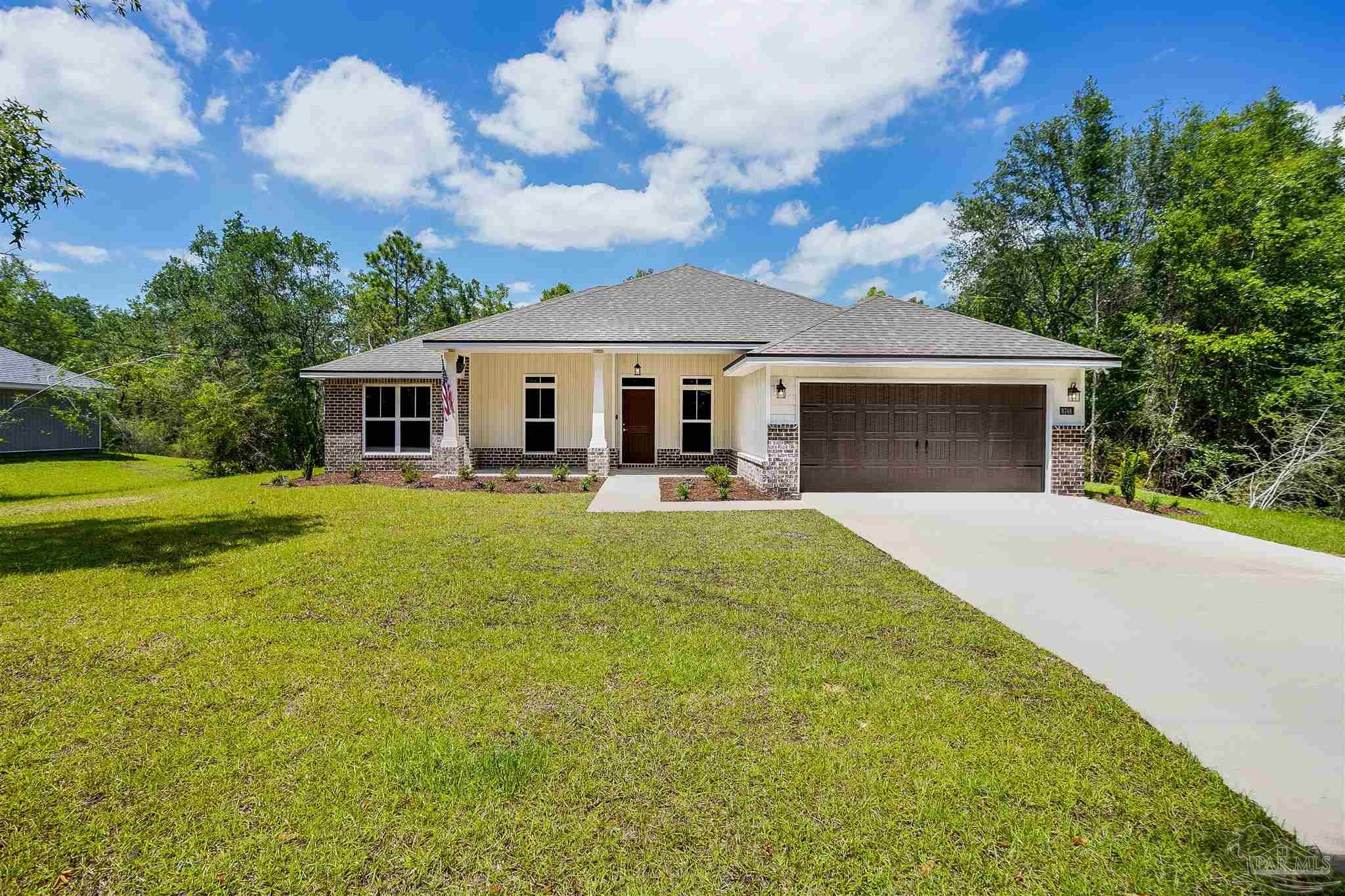 a front view of a house with yard patio and green space