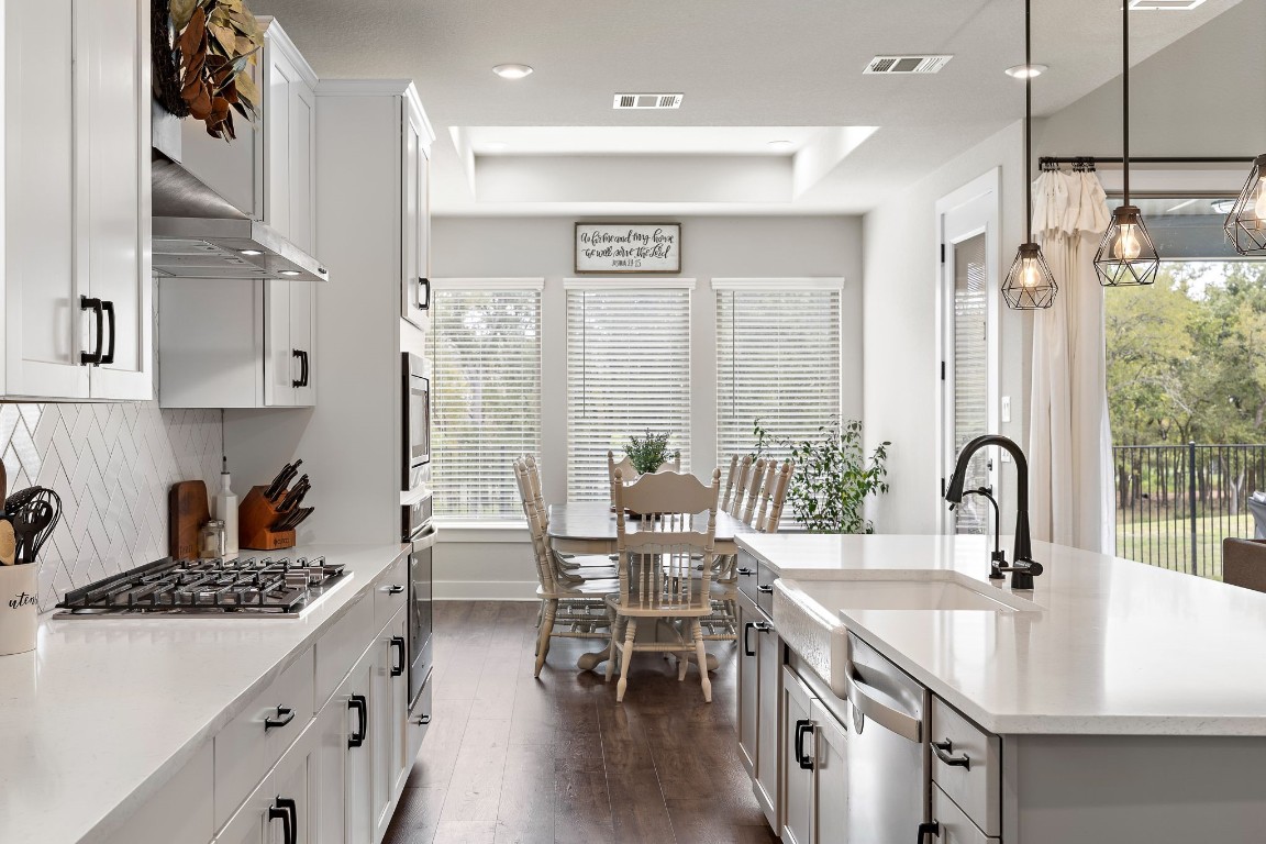 a kitchen with stainless steel appliances granite countertop a sink stove and cabinets