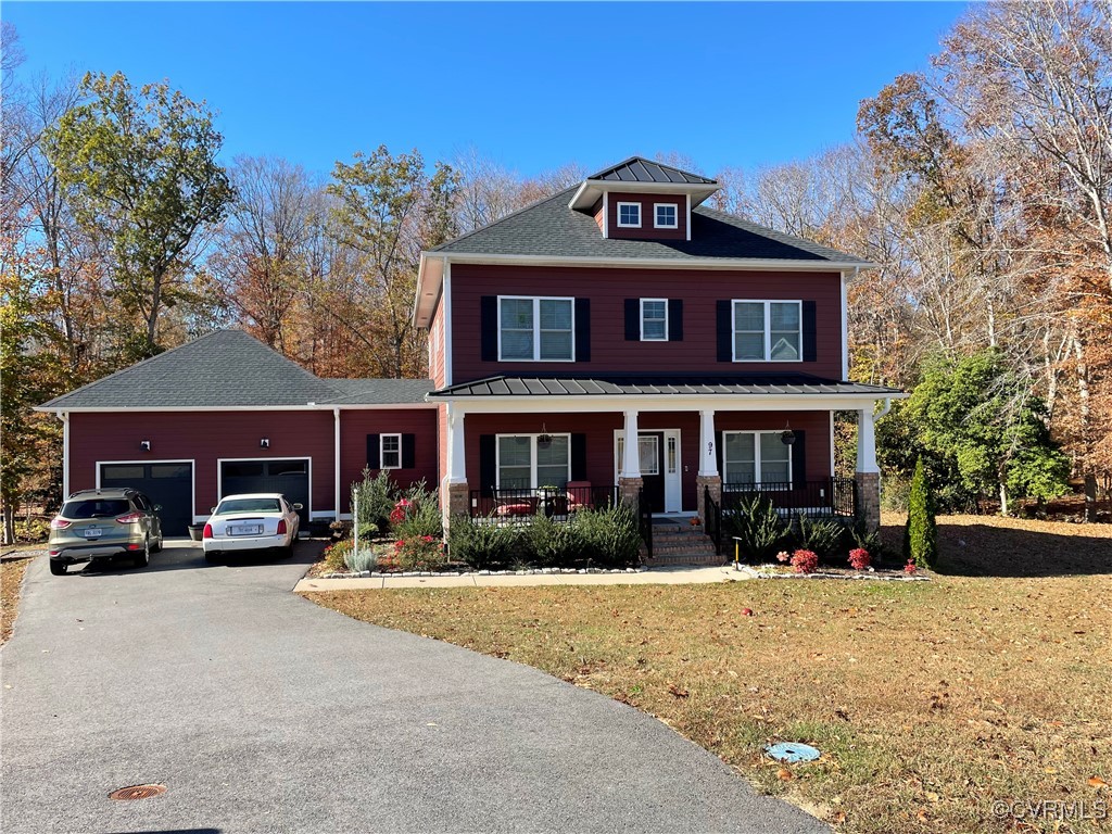 View of front of home featuring a front lawn, a ga