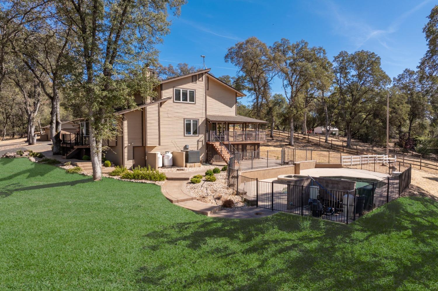 a view of a house with backyard and sitting area