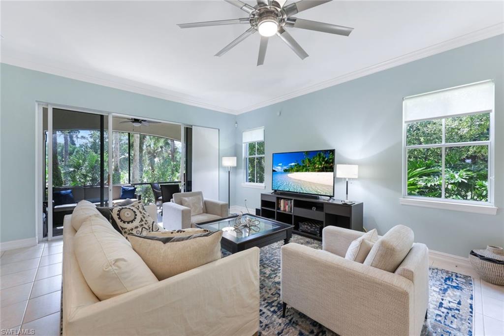 a living room with furniture a large window and a flat screen tv