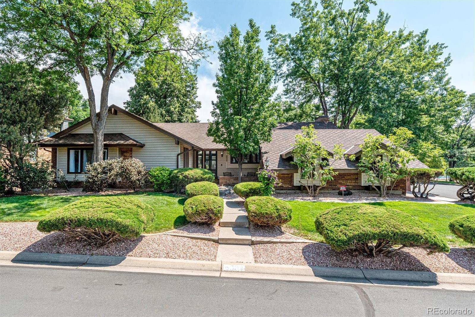 a front view of a house with a yard and potted plants