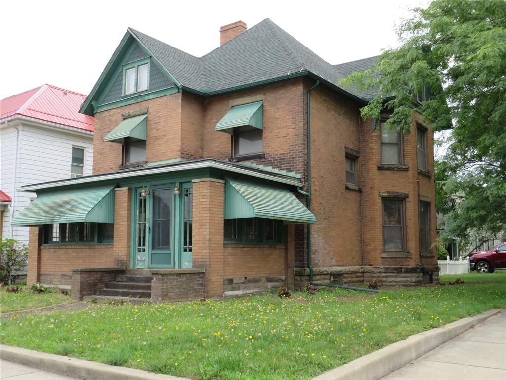 a front view of a house with a garden and plants