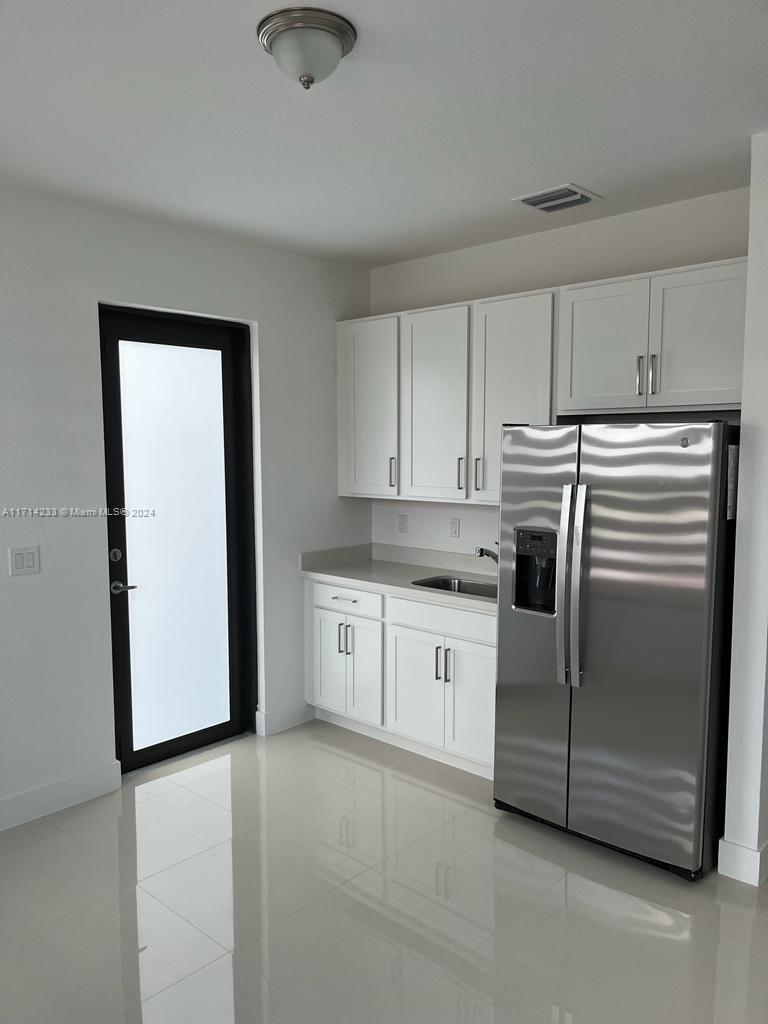 a kitchen with a refrigerator sink and cabinets