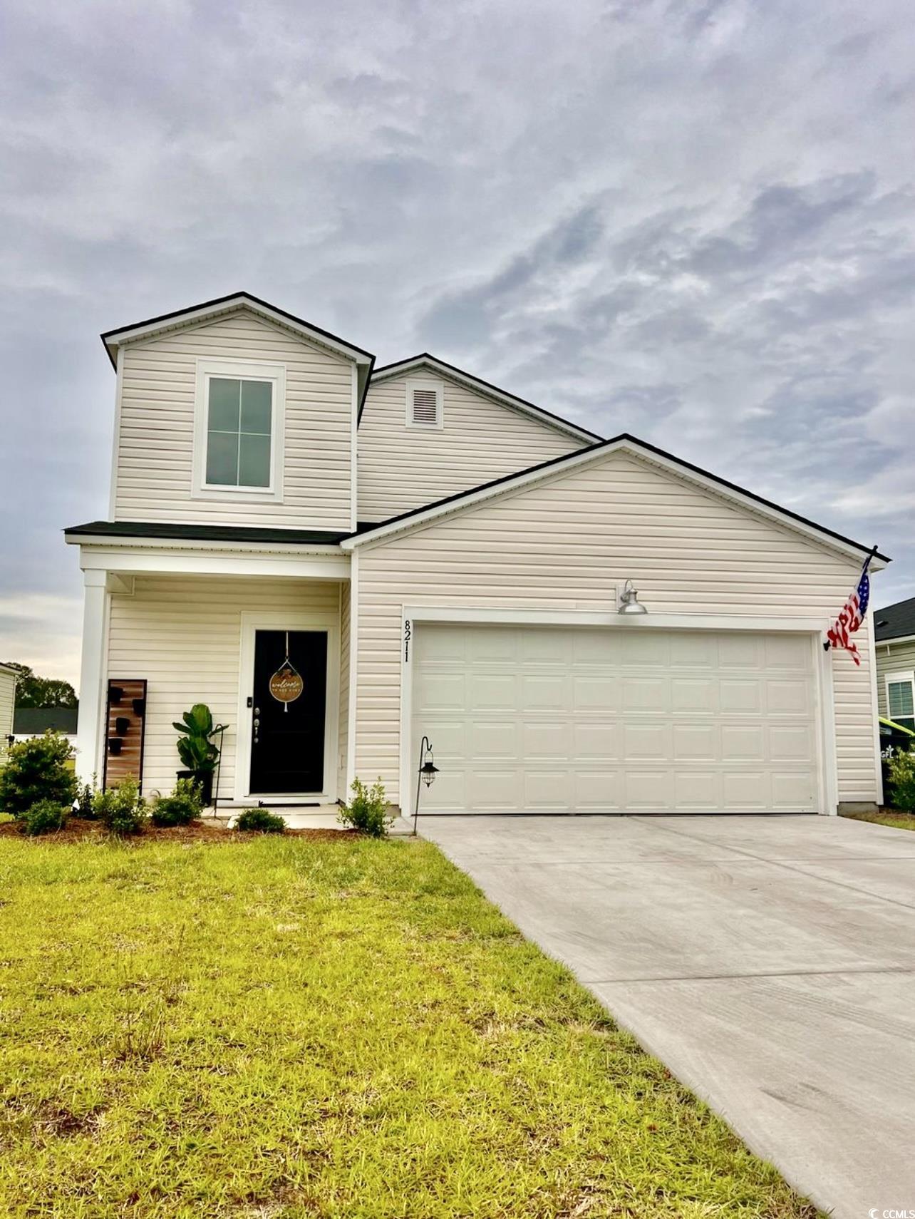 View of front of home with a garage and a front ya