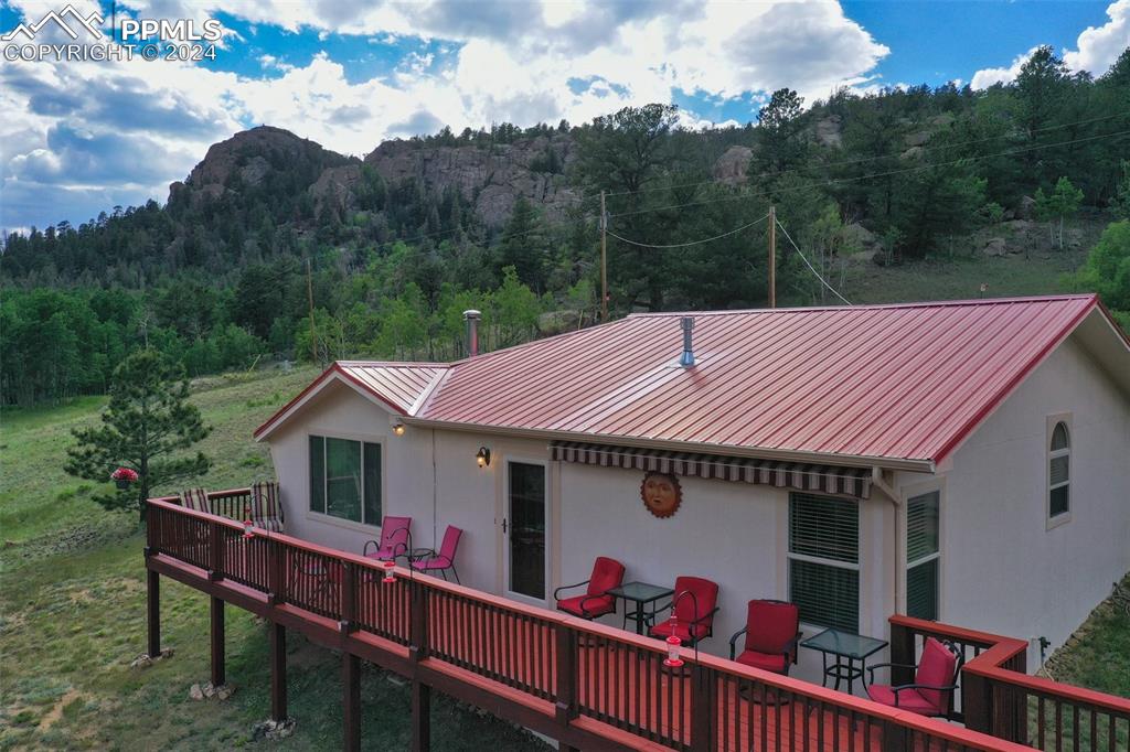 Rear view of property with a wooden deck and a yard