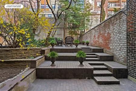 a view of flower garden with wooden bench