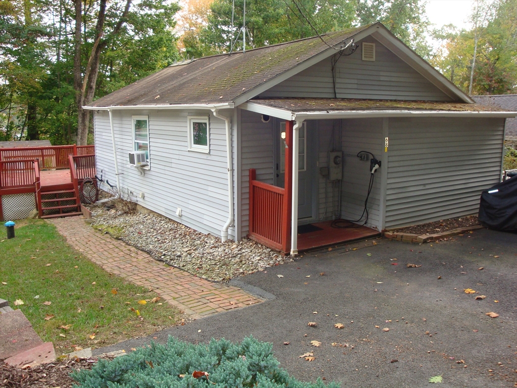 a small white house with a white roof and table and chairs under an umbrella