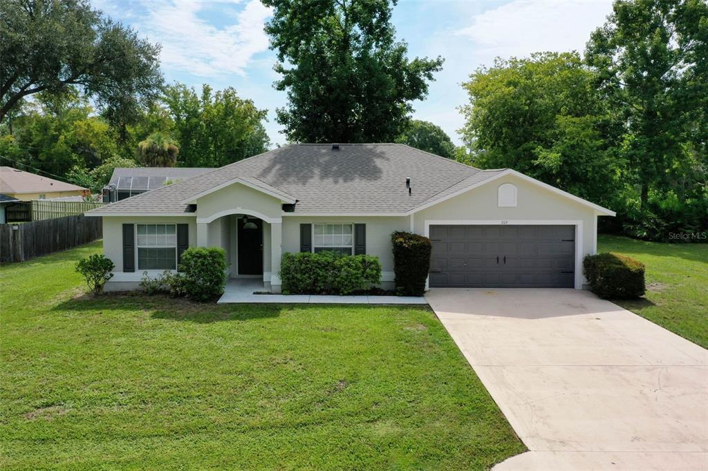 a front view of a house with a yard garage and trees