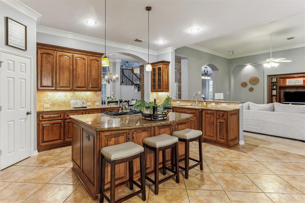 7014 Lake Haven Ct, Sugar Land Tx 77479-Stainless steel appliances, including a double oven and a spacious refrigerator, add a modern touch and ensure you have all the tools needed for culinary excellence. The backsplash and tile flooring complement the overall design, adding texture and depth to the space.