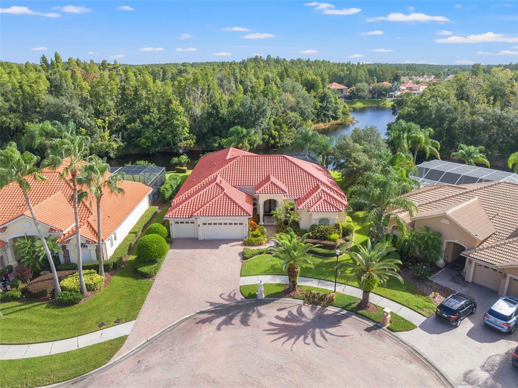 an aerial view of a house with a garden and lake view