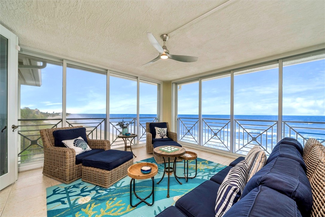 a living room with furniture ceiling fan and a floor to ceiling window