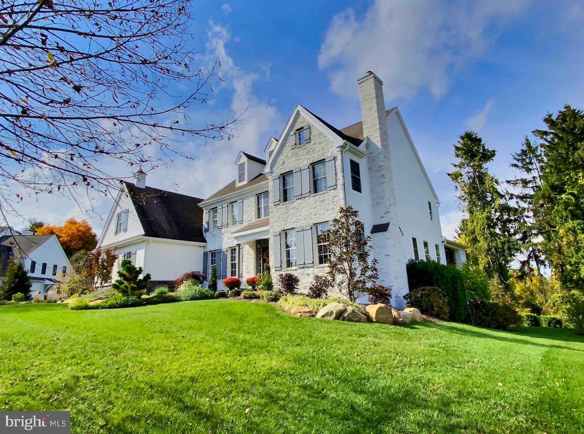 a front view of a house with a big yard and a large tree