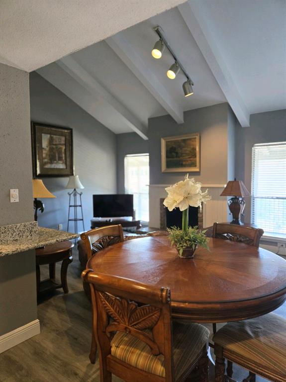 a kitchen with kitchen island granite countertop a dining table chairs and refrigerator