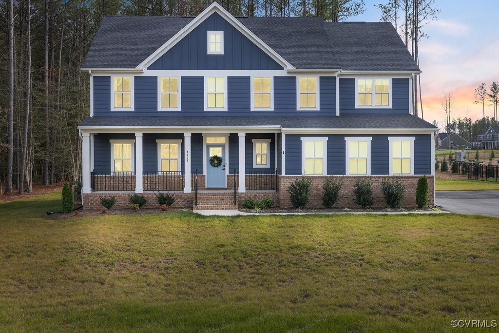 a view of a brick house with a yard plants and large trees