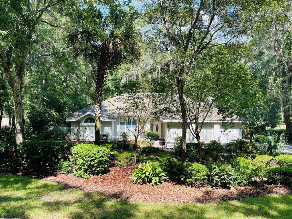 a front view of a house with a yard and fountain in middle