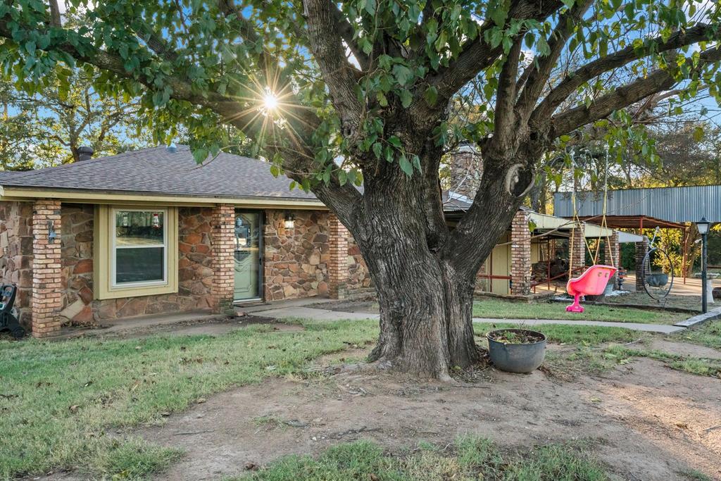 a view of a house with a tree in front of it