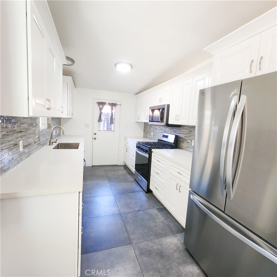 a kitchen with stainless steel appliances a refrigerator sink and stove