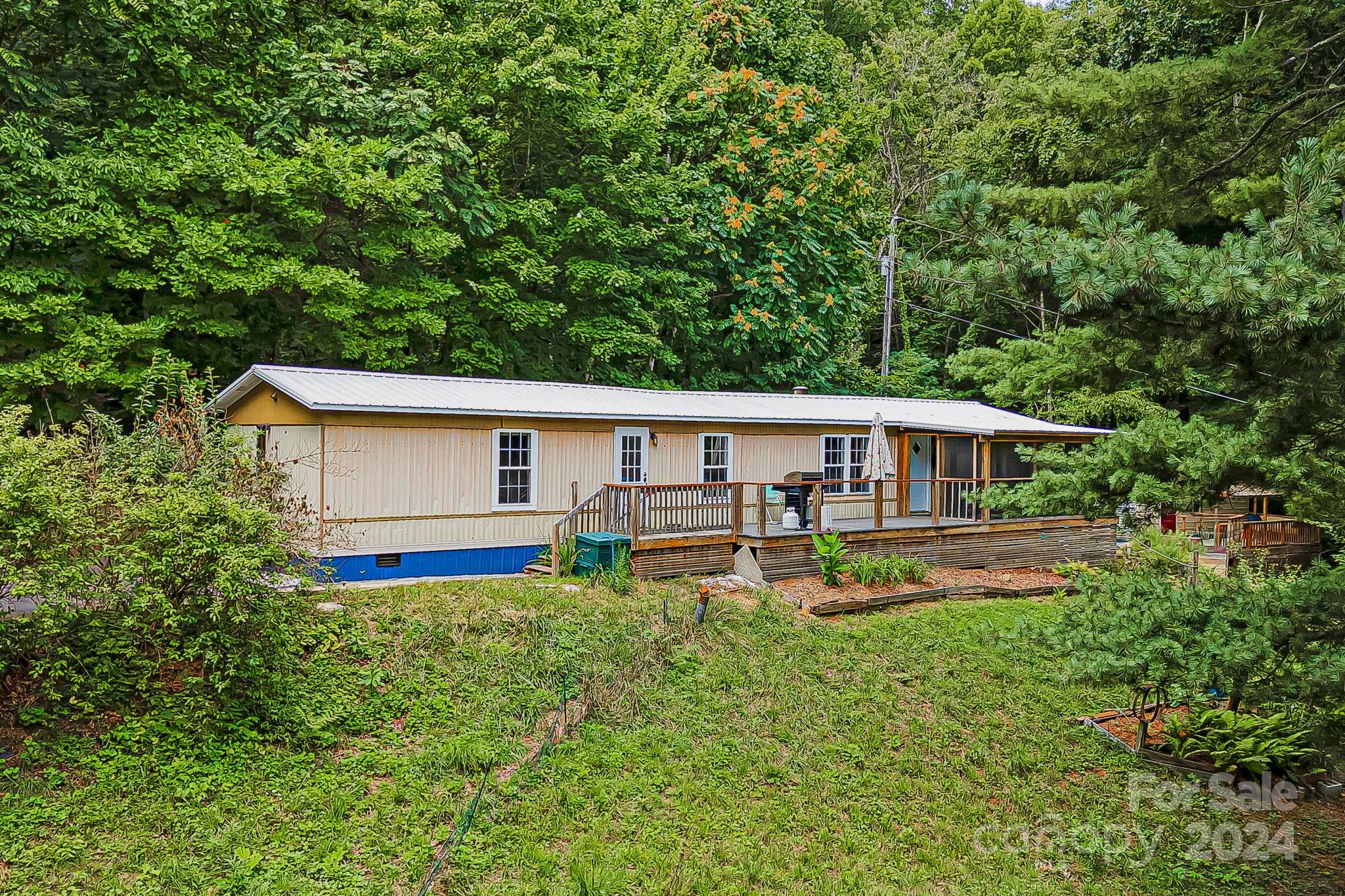 a front view of house with yard and trees in the background