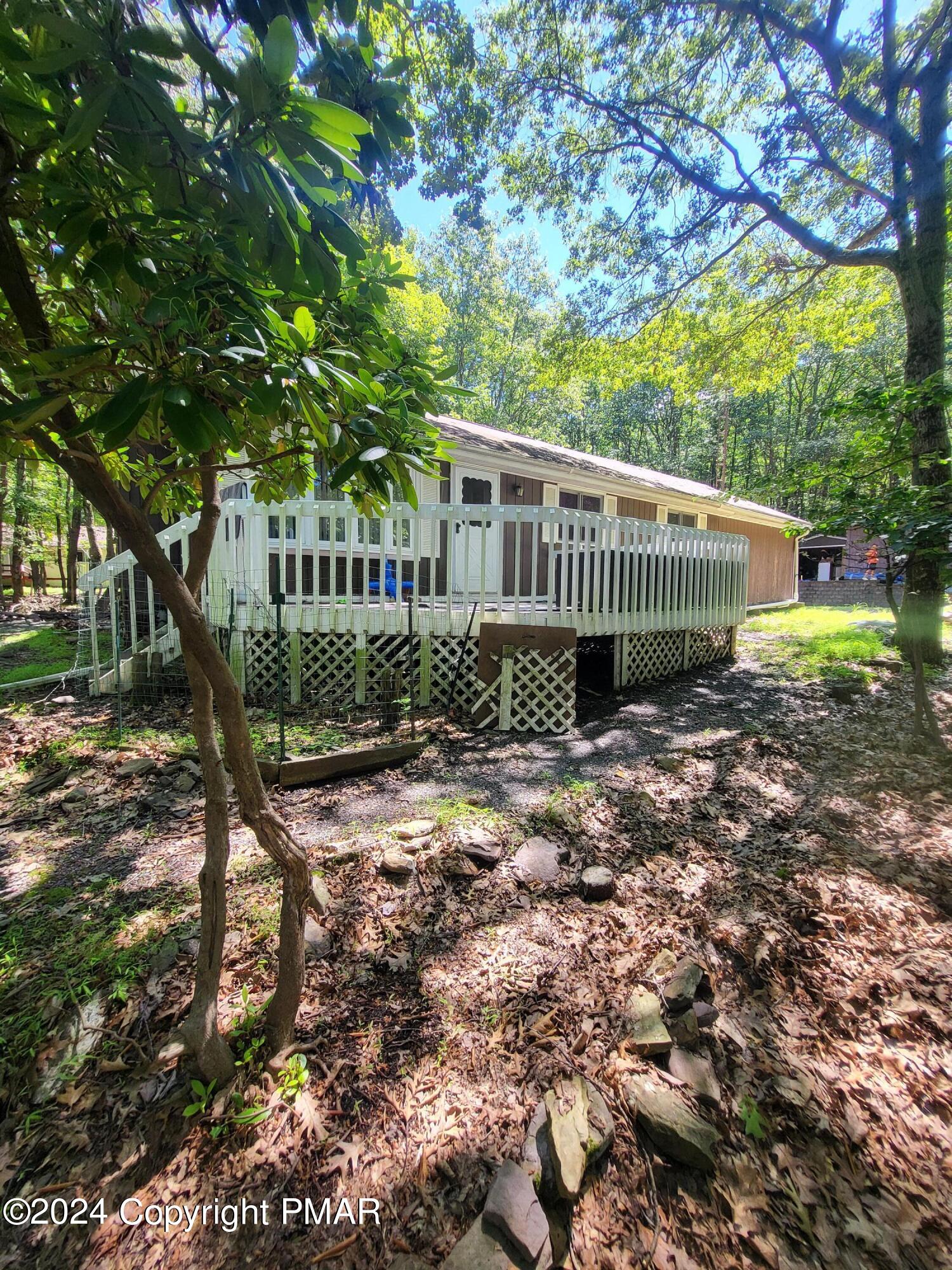 a view of a house with a yard and large trees