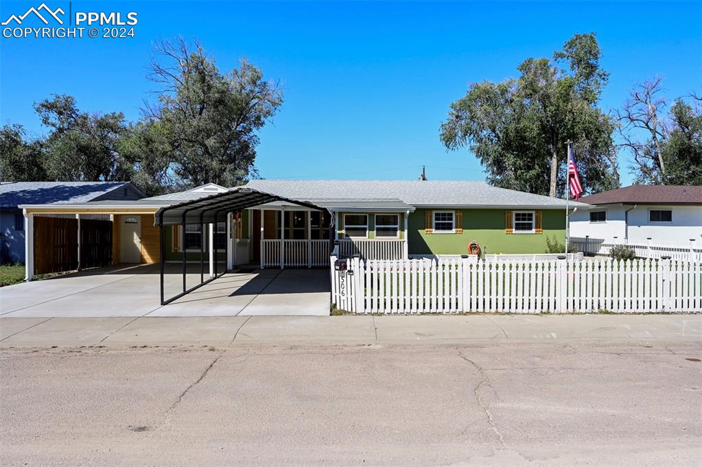 Ranch-style house featuring a front lawn and a carports