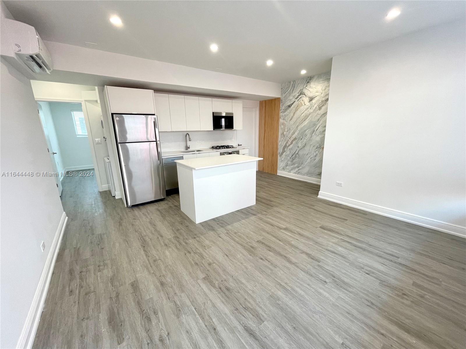 a view of kitchen with stainless steel appliances refrigerator stove microwave and cabinets